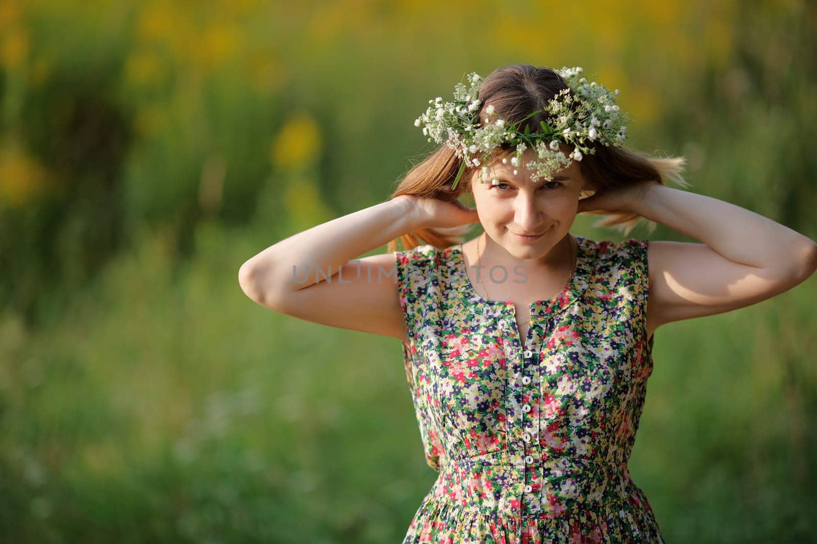 A smiling girl with a wreath on his head and straightens her hair looking at the camera. Sunset light. Shallow depth of field. Focus on eyes. Space for text.