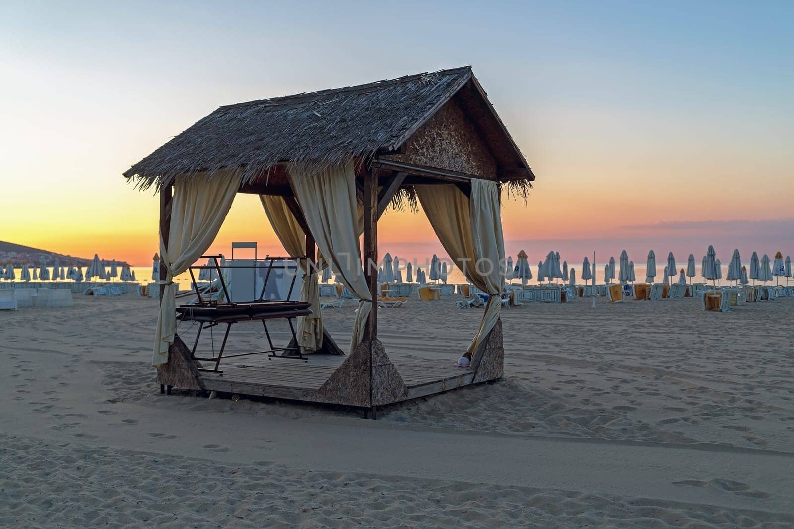 Massage canopy on a sandy beach in the early morning. Shallow depth of field. Focus on foreground.