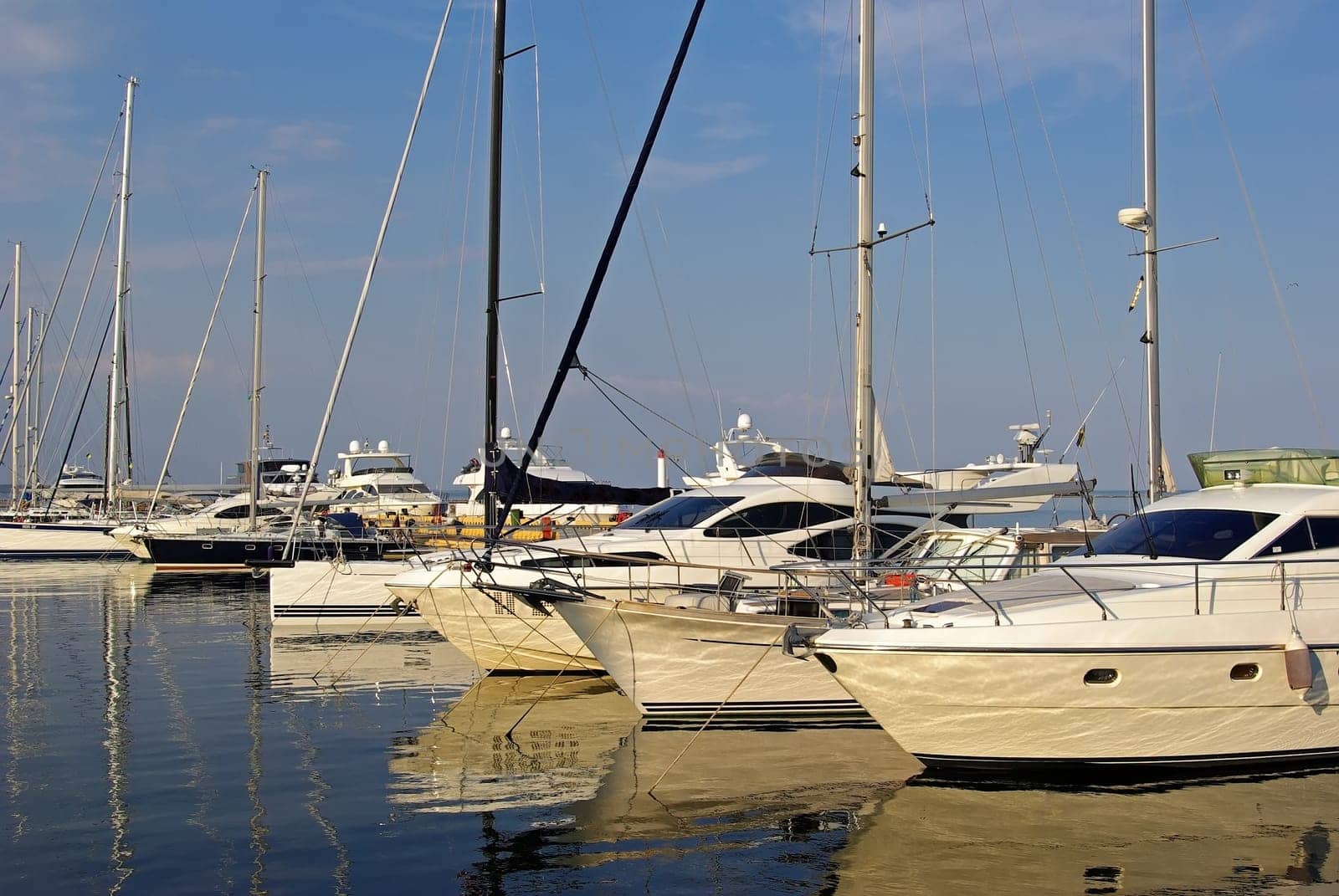 Beautiful white modern luxury yachts at seaport. Sunny summer day.