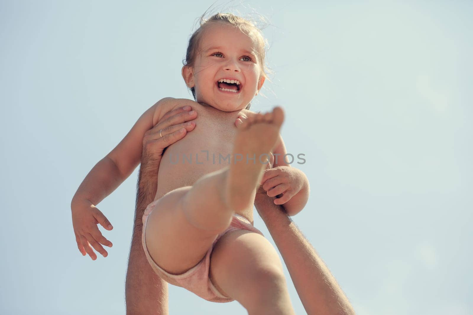 Happy baby in father's hands. Toned image. Shallow depth of field. Selective focus.
