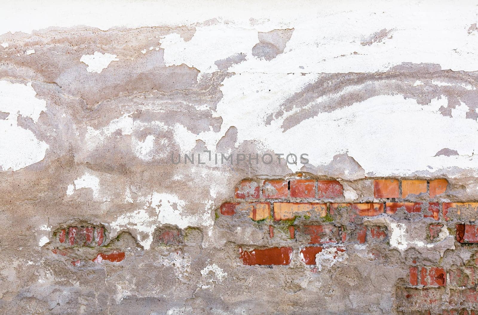 Grunge background. Old vintage dirty brick wall with peeling plaster.