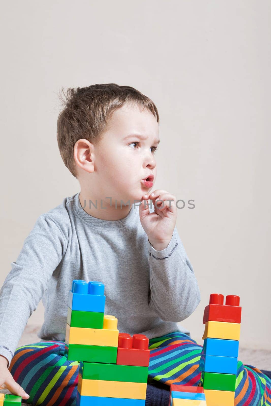 Playing little boy with colored cubes