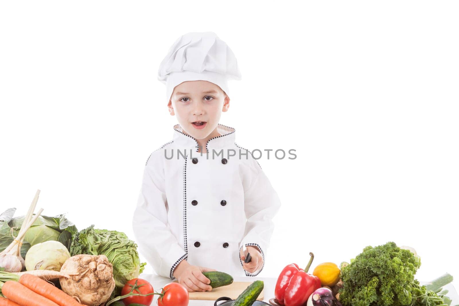 One little boy as chef cook making salad, cooking with vegetables. Isolated on white.