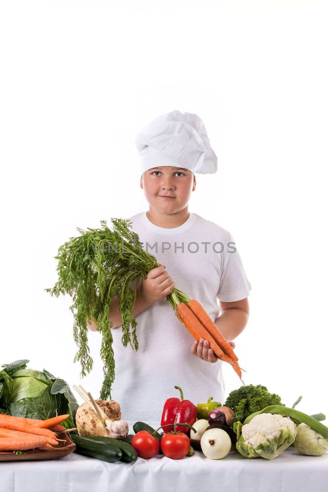 One little boy as chef cook making salad, cooking with vegetables. Isolated on white.
