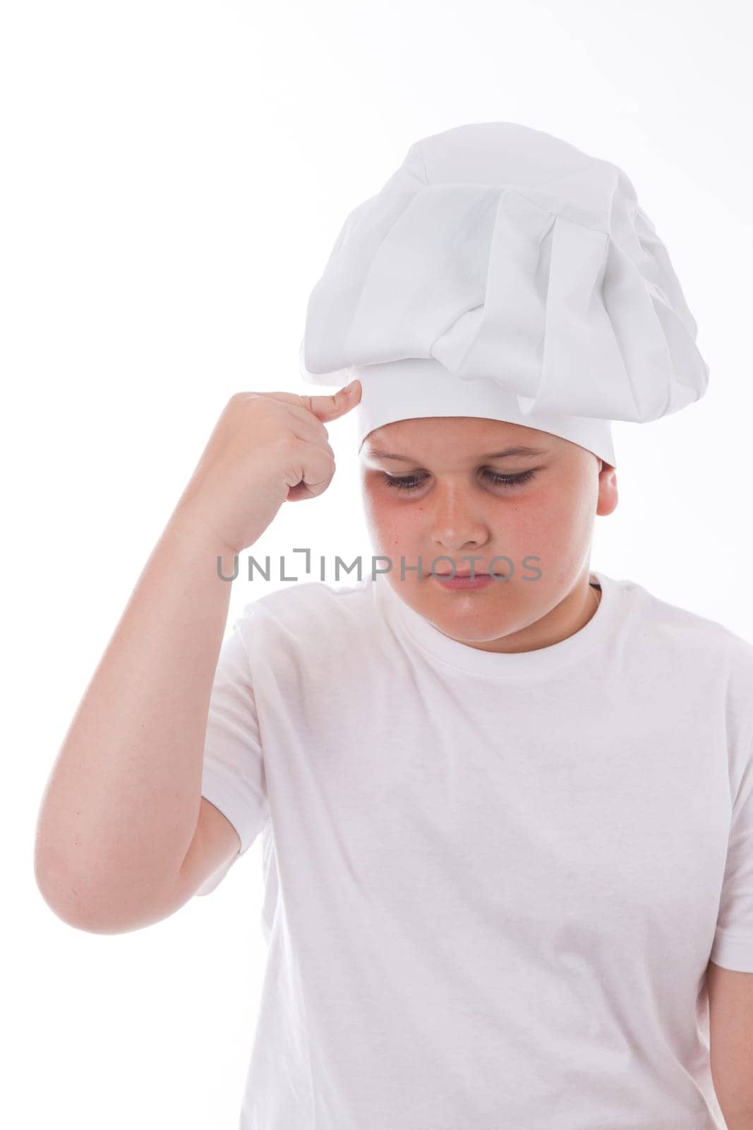 One little boy as chef cook making salad, cooking with vegetables. Isolated on white.