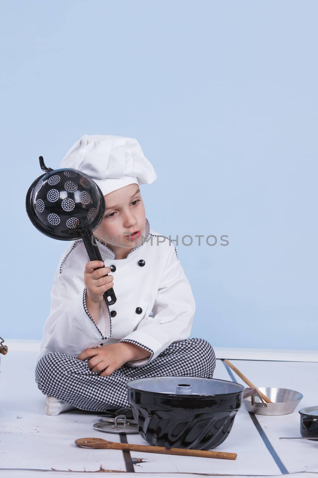 One little boy as chef cook making salad, cooking with vegetables. Isolated on white.
