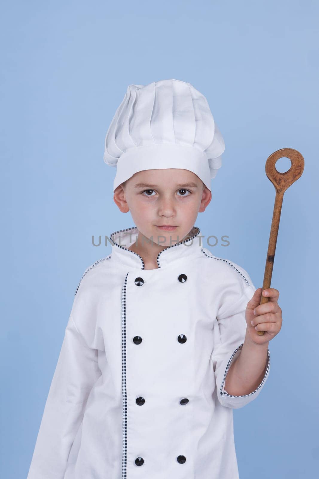 One little boy as chef cook making salad, cooking with vegetables. Isolated on white.