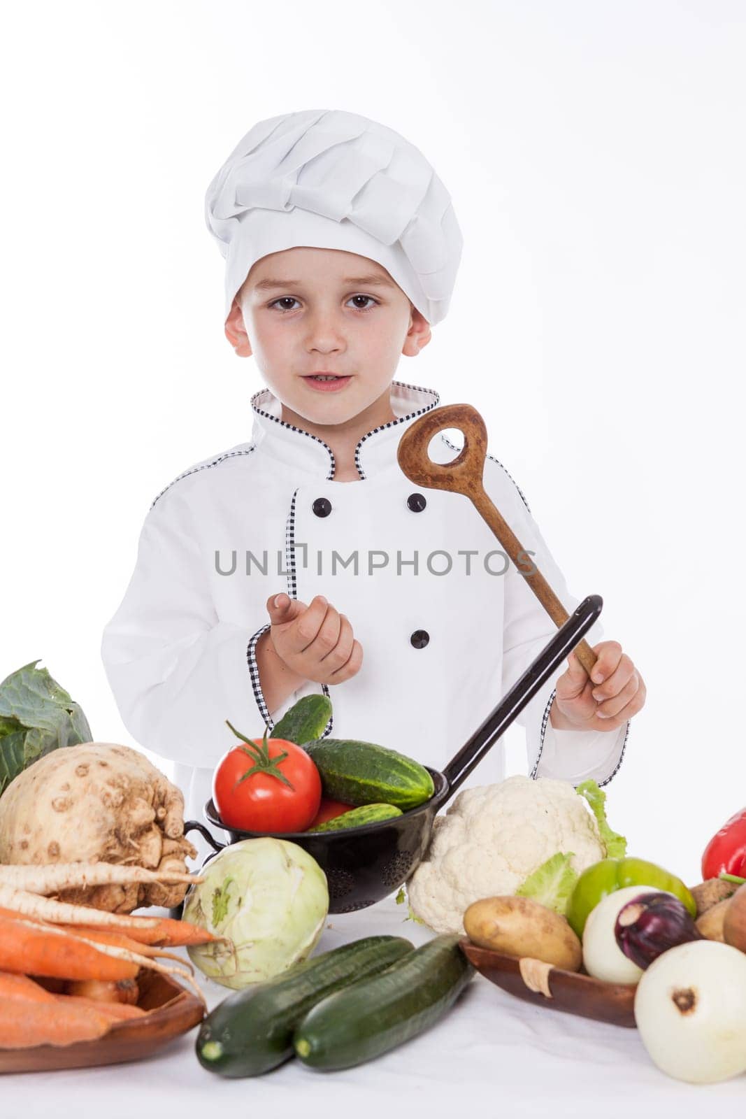 One little boy as chef cook making salad, cooking with vegetables. Isolated on white.