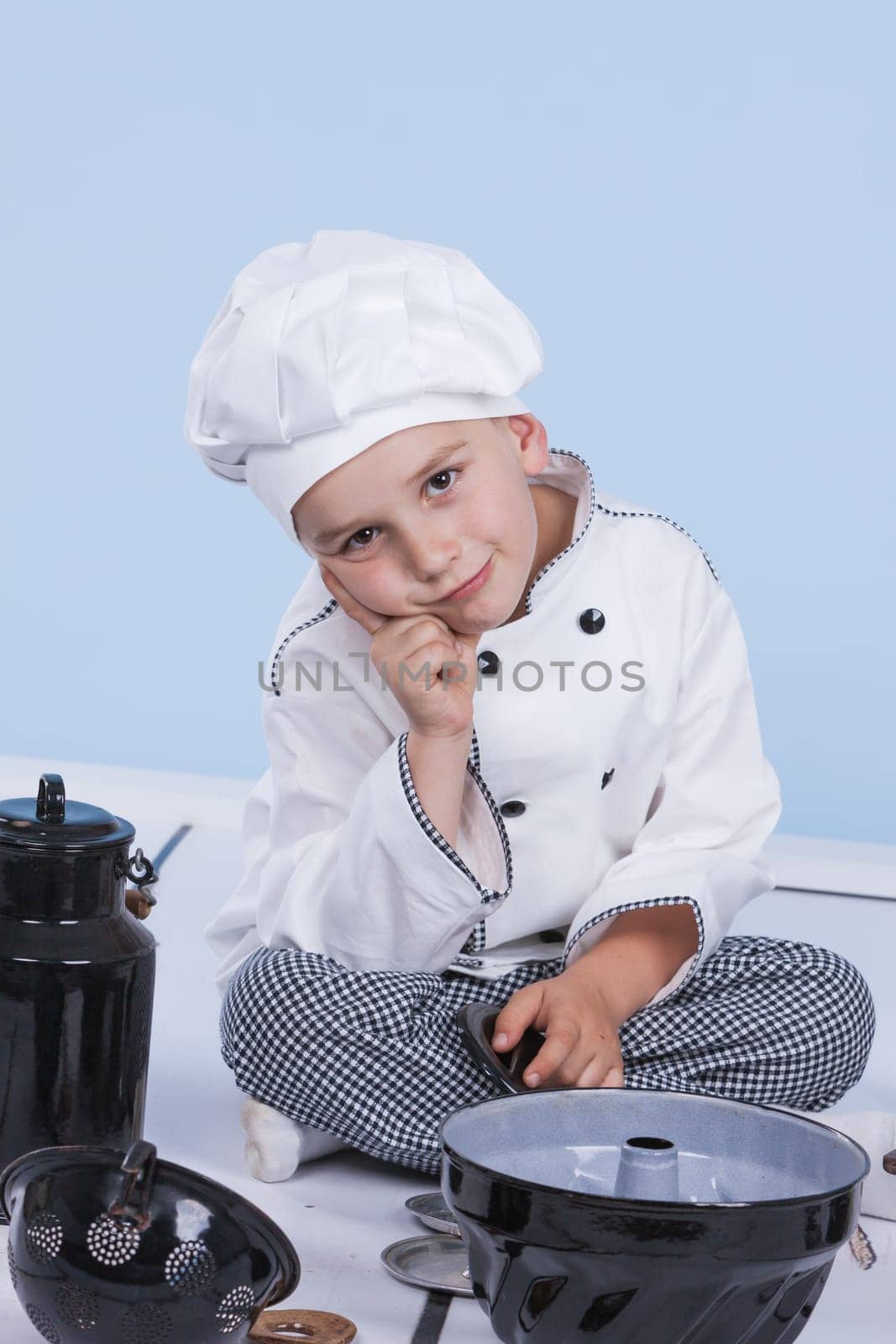 One little boy as chef cook making salad, cooking with vegetables. Isolated on white.