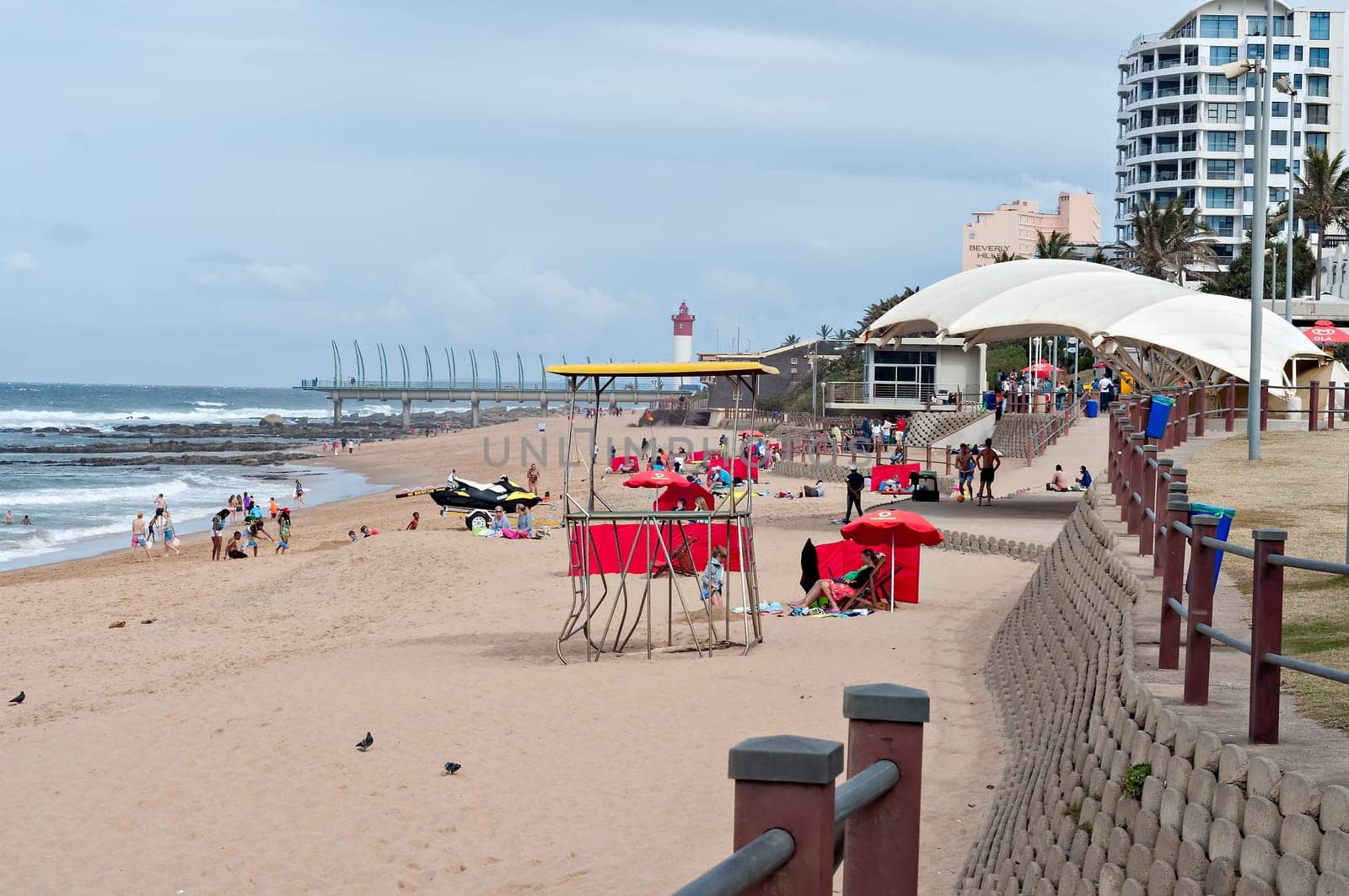 DURBAN, SOUTH AFRICA - JULY 09, 2016: Locals and tourists on the beach near the Millennium Pier and lighthouse in Umhlanga Rocks