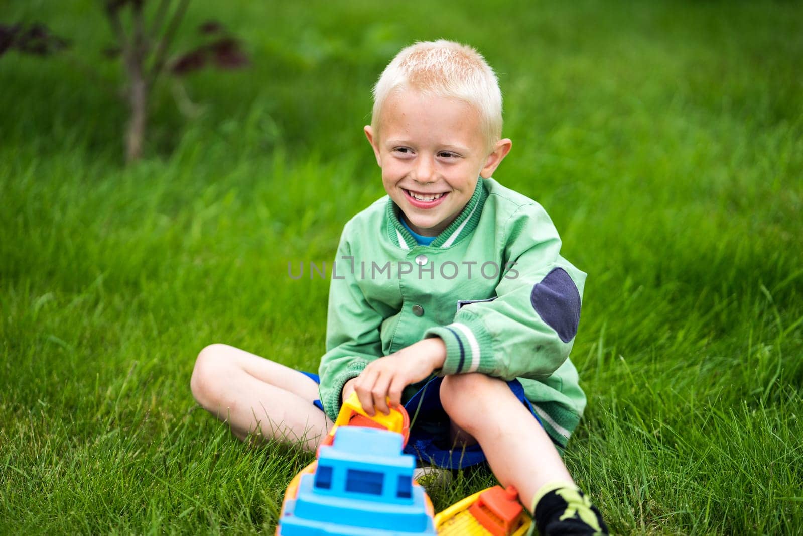 Little boy playing with his toys in the garden