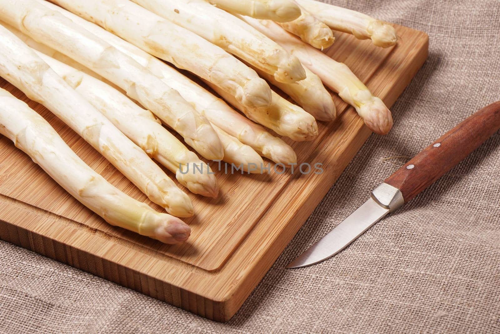 Delicate organic white asparagus ready to be peeled before they can be steamed