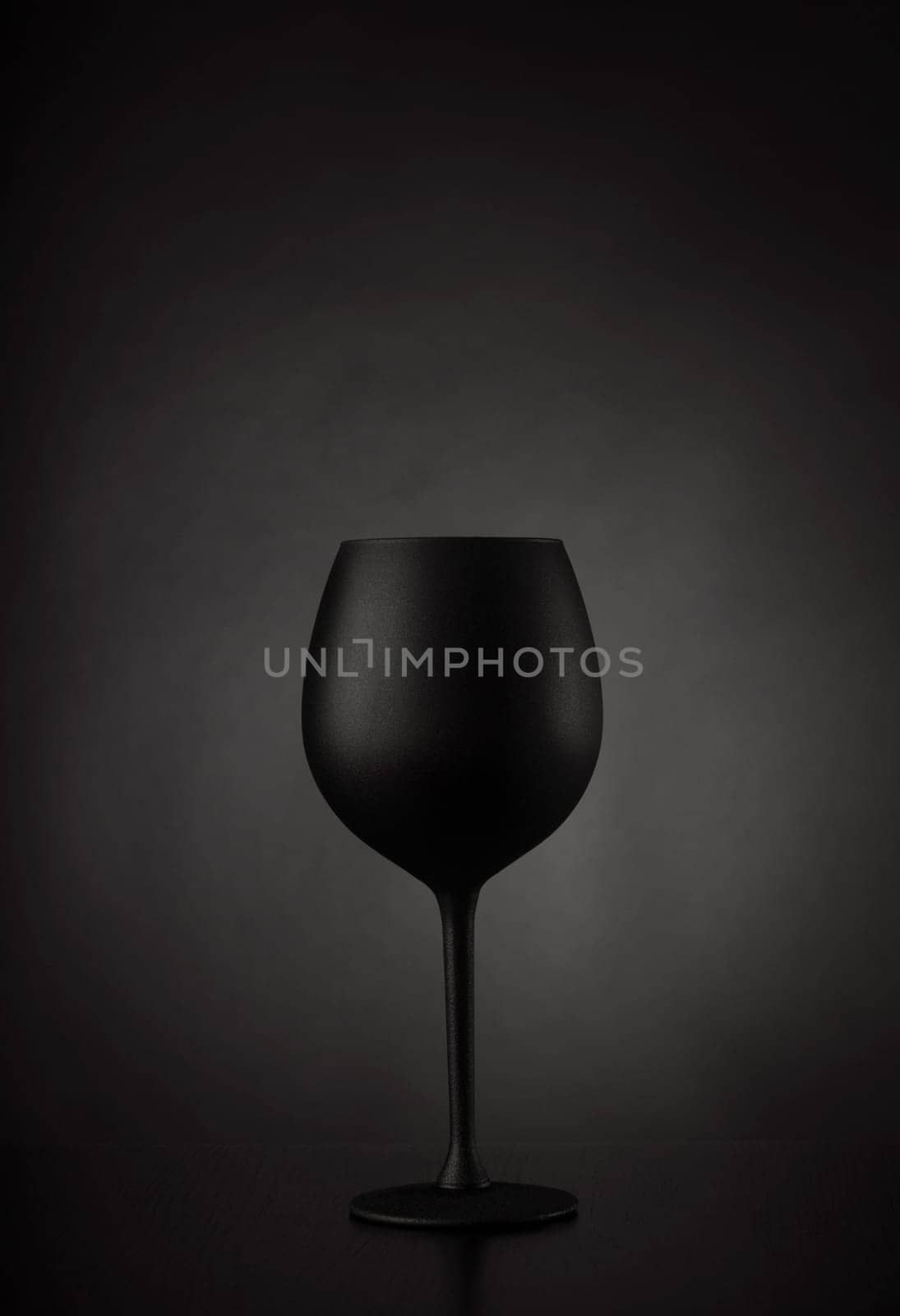 Black glass of wine on black background