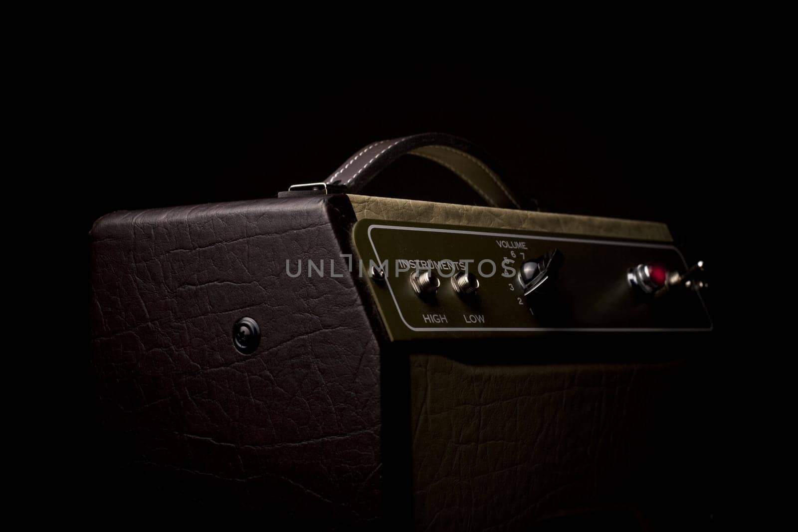 Horizotal picture of a leather finished guitar amplifier on black background viewed from the side