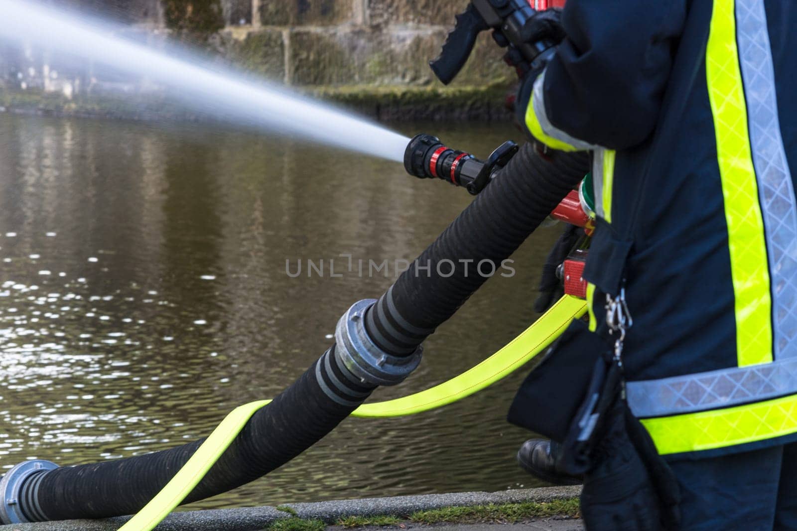Fire department sprays extinguishing water from fire hoses during an exercise..