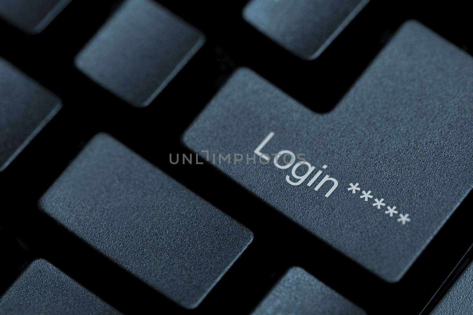 Horizontal close up of black keys on a keyboard with the word login on one of them