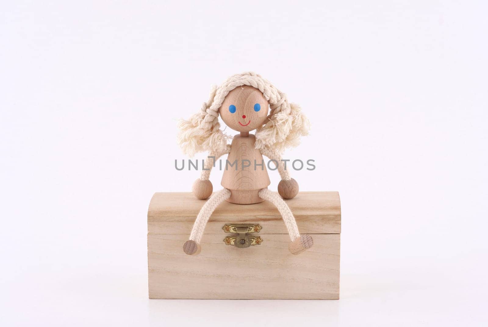 hand made wooden girl sitting on a wooden chest