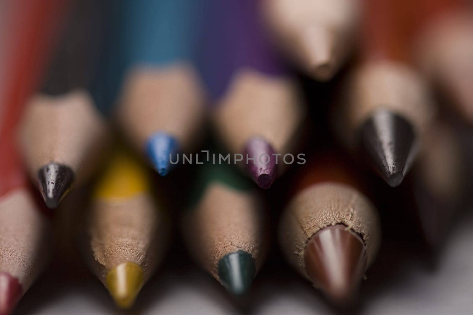 Group of colored pencils with shallow depth of field on grey background.