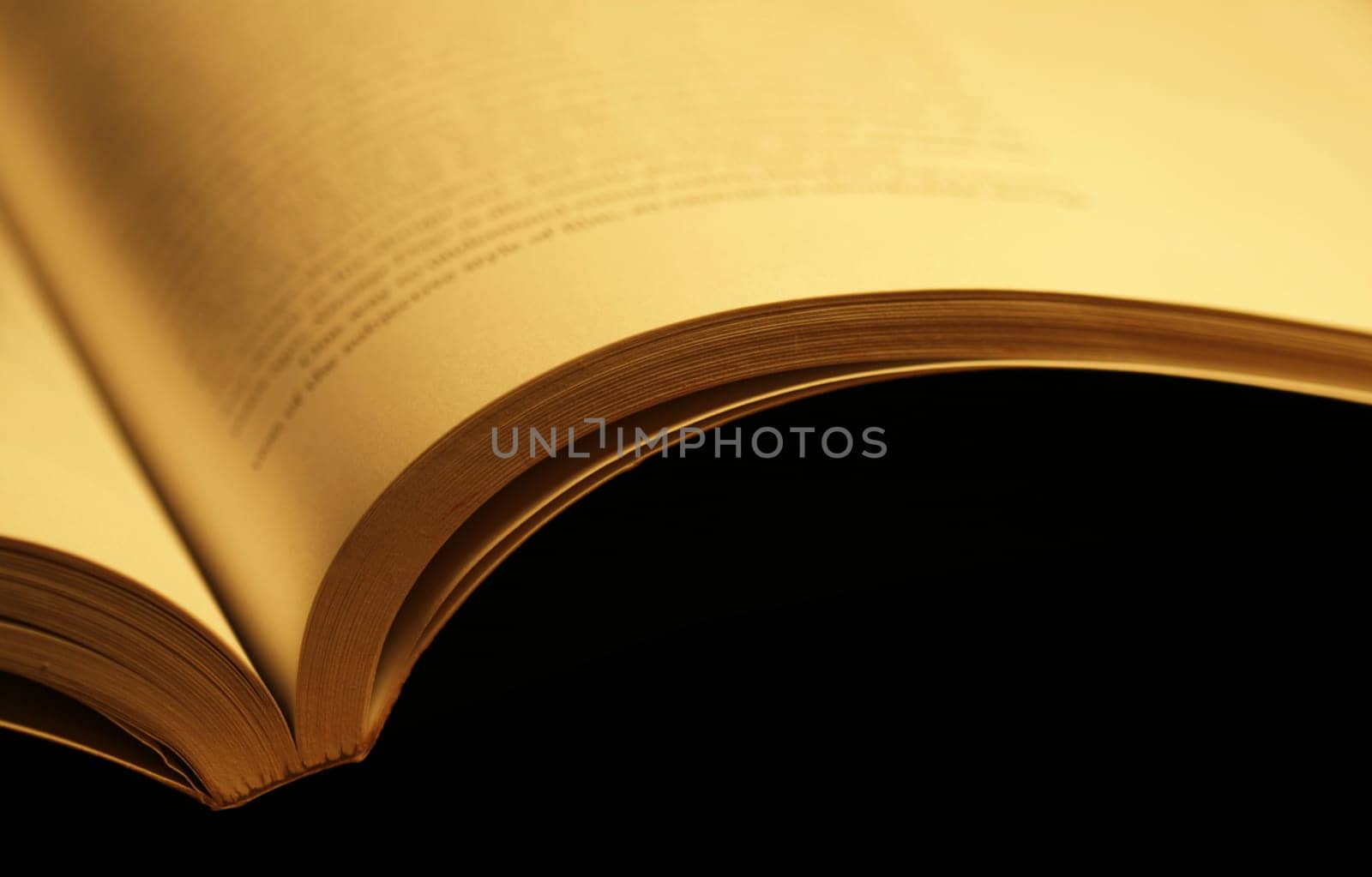 Horizontal photo of an old open book on black background