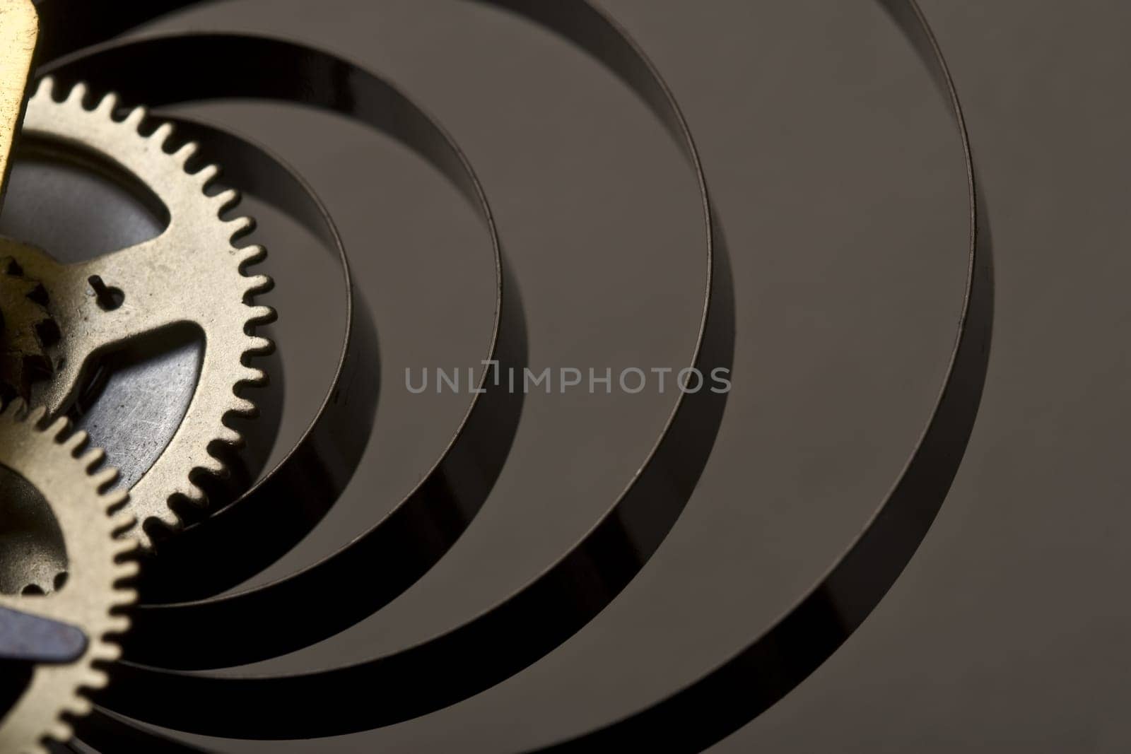 Horizontal close up on the golden cogs of a mechanical clock