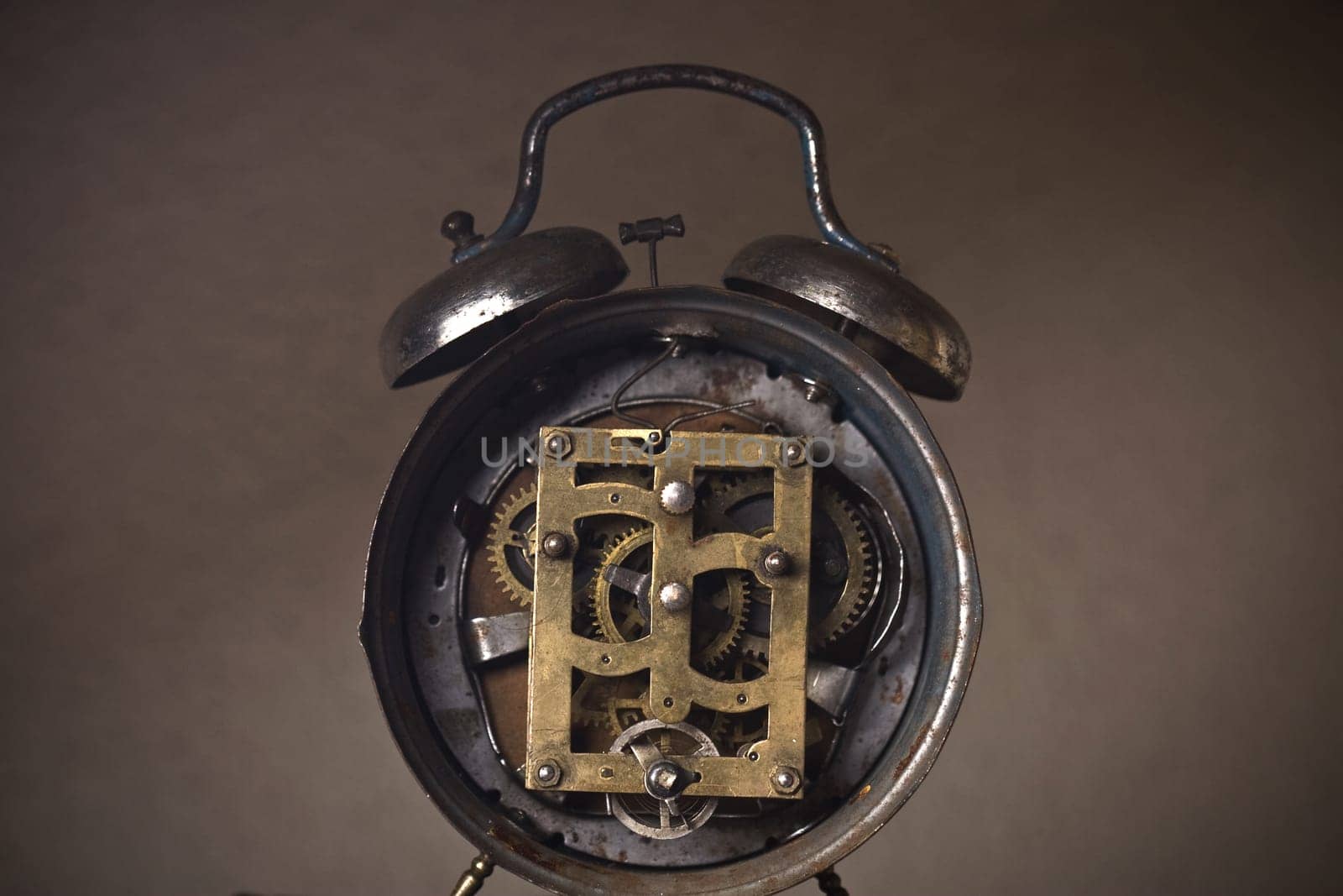 Back of an old rusted clock with its mechanism and cogs revealed