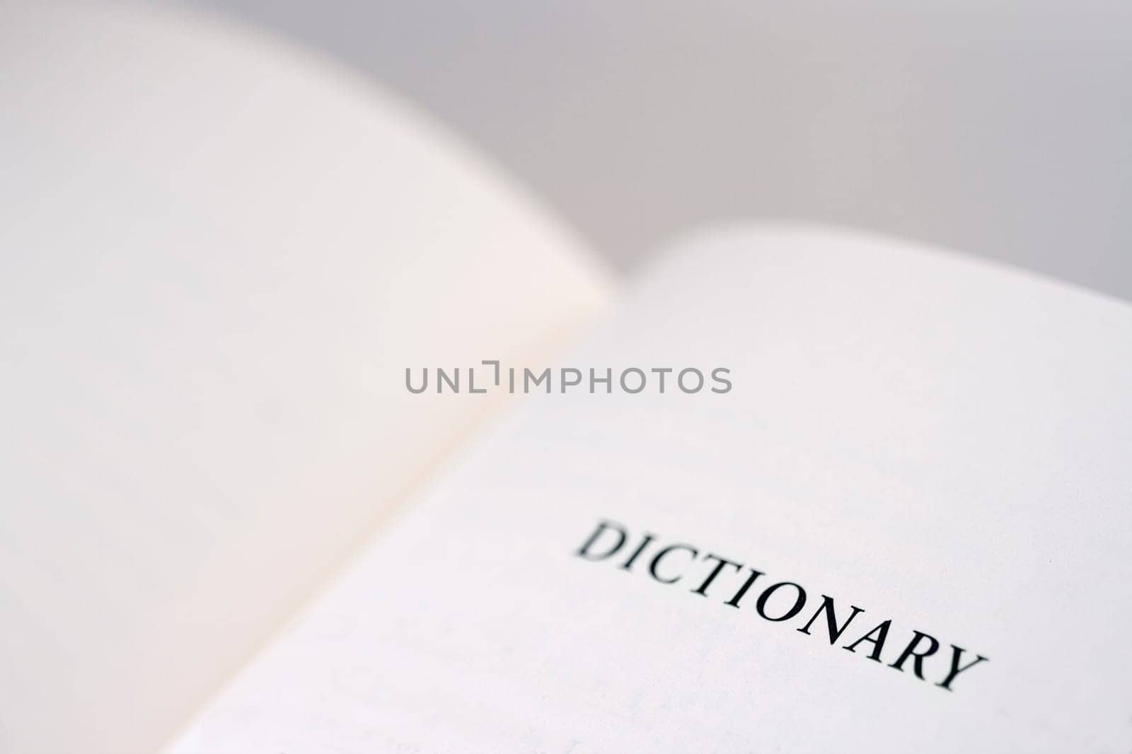 An open book with the word dictionary reading on the right page, copy space available.