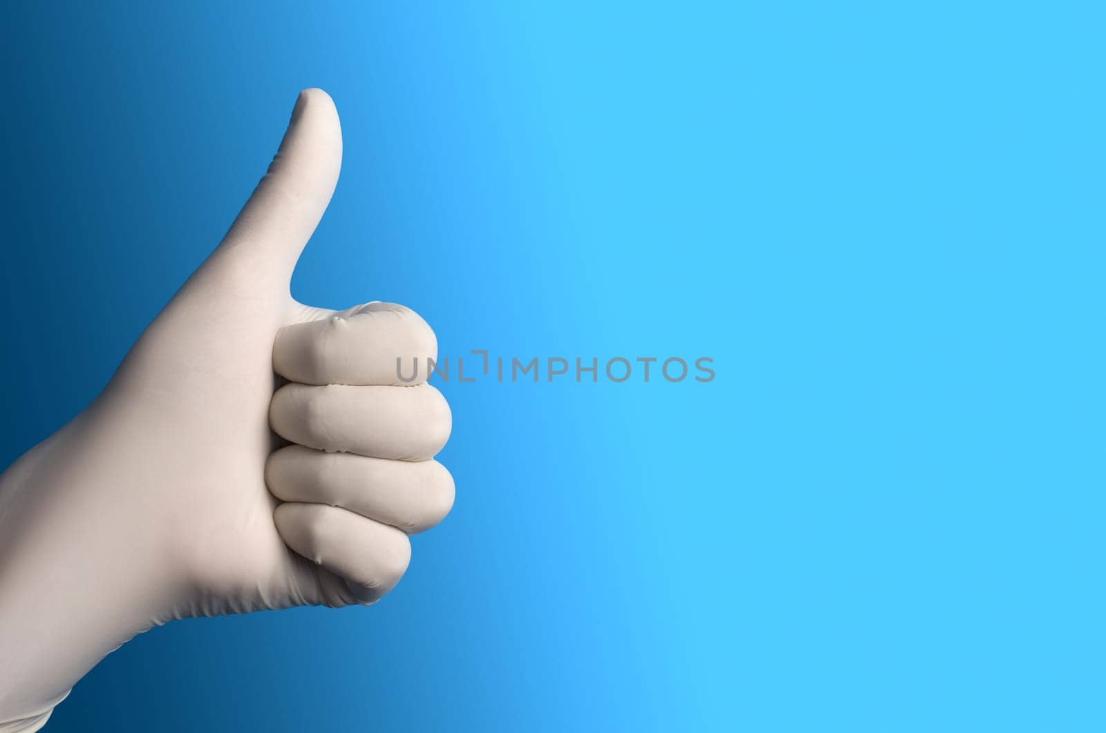Hand with a white surgical glove showing the thumb up sign against a blue background