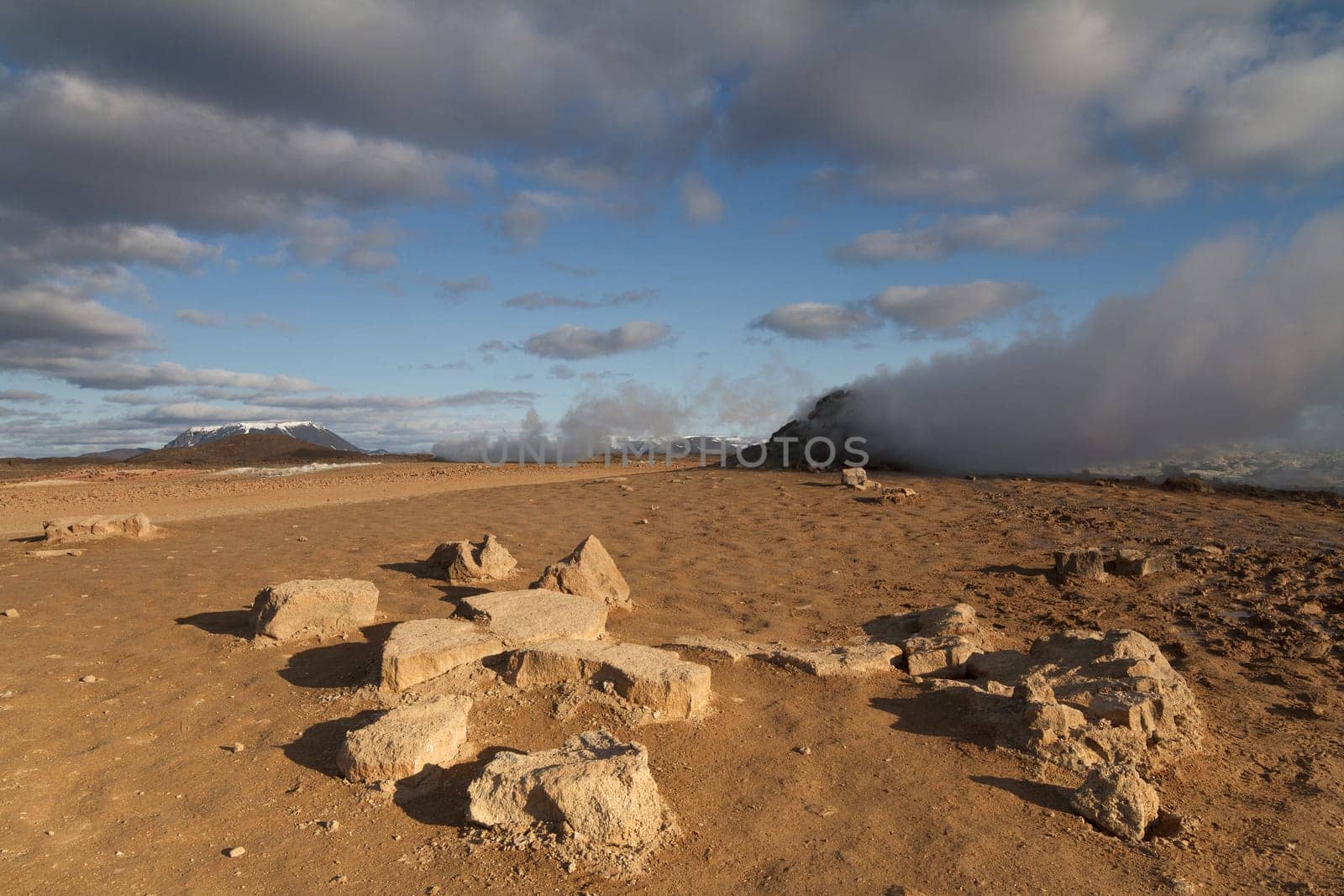 Horizontal view of steam hot springs coming out of the ground in the volcanic valley near Myvatn baths in Iceland