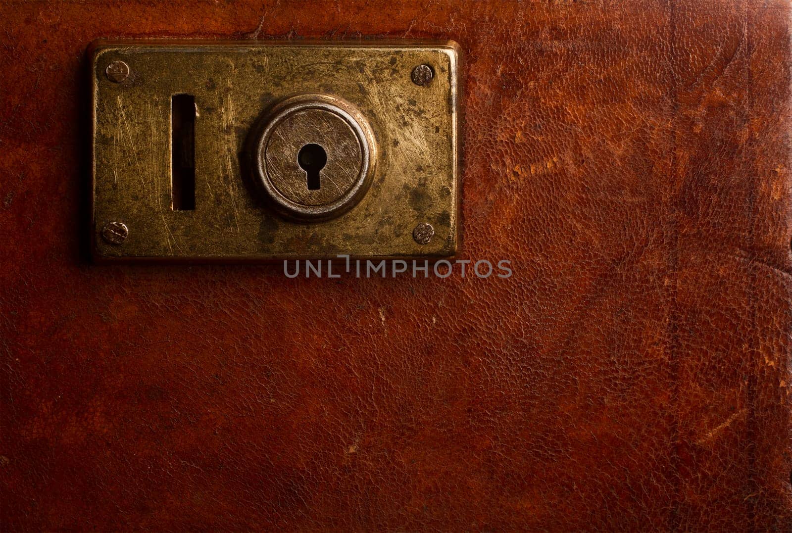 Horizontal close up of an old locking mechanism on a vintage suitcase made of brown leather