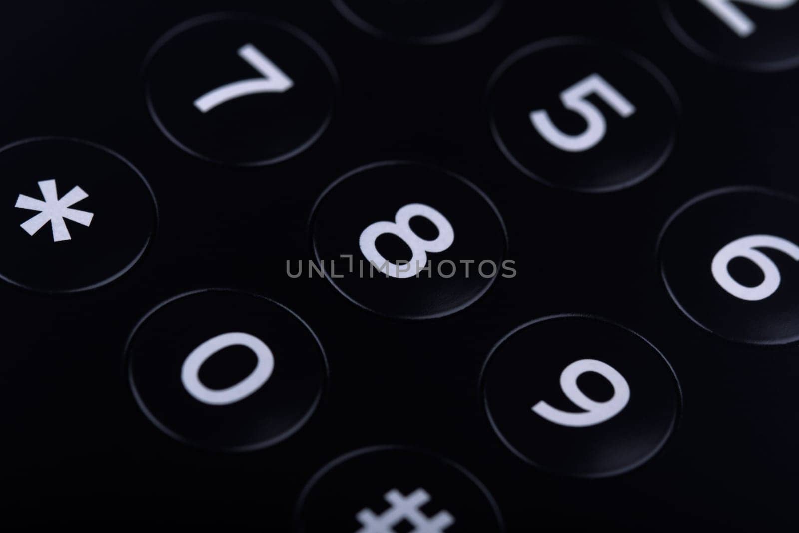 Horizontal top view close up of the keypad of a telephone with numbers showing