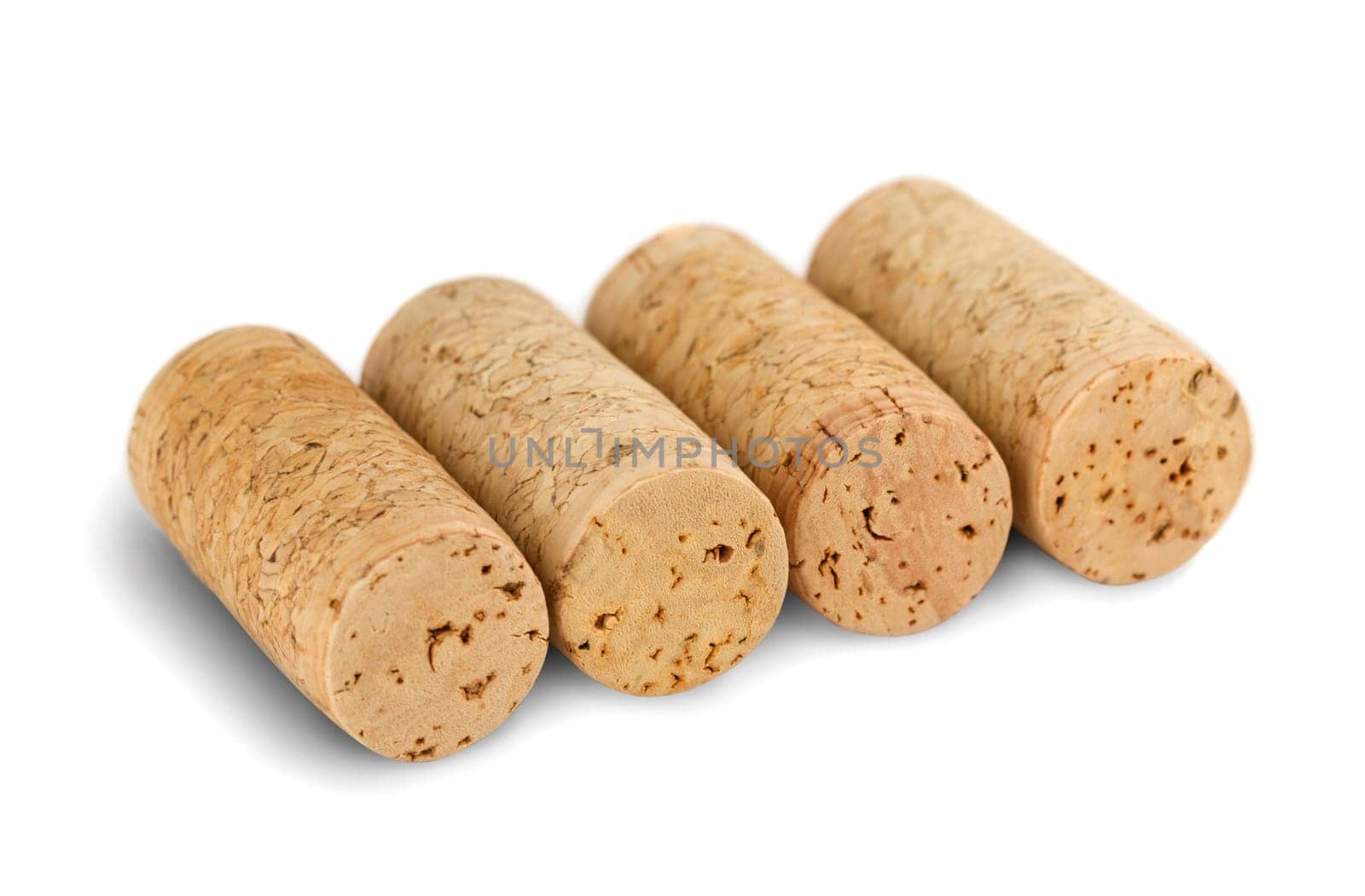 four wine corks arranged in a row, isolated on white background
