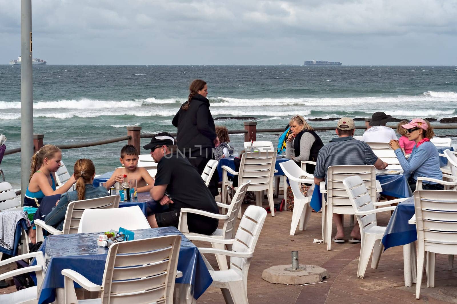 DURBAN, SOUTH AFRICA - JULY 09, 2016: Locals and tourists at a restaurant on the promenade at the beach in Umhlanga Rocks beach