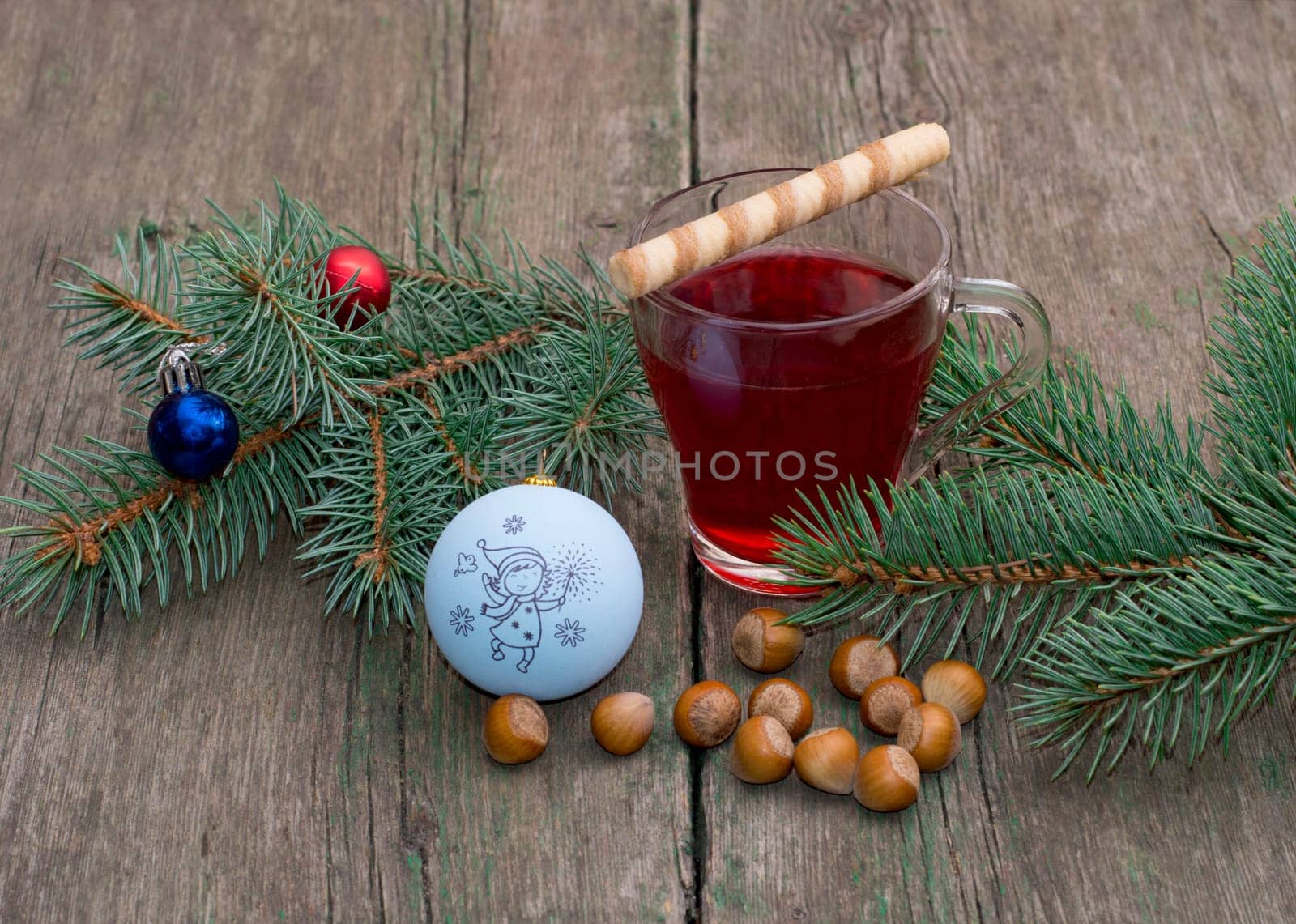coniferous branch with Christmas tree decorations, tea and nutlets, the subject Christmas and New Year