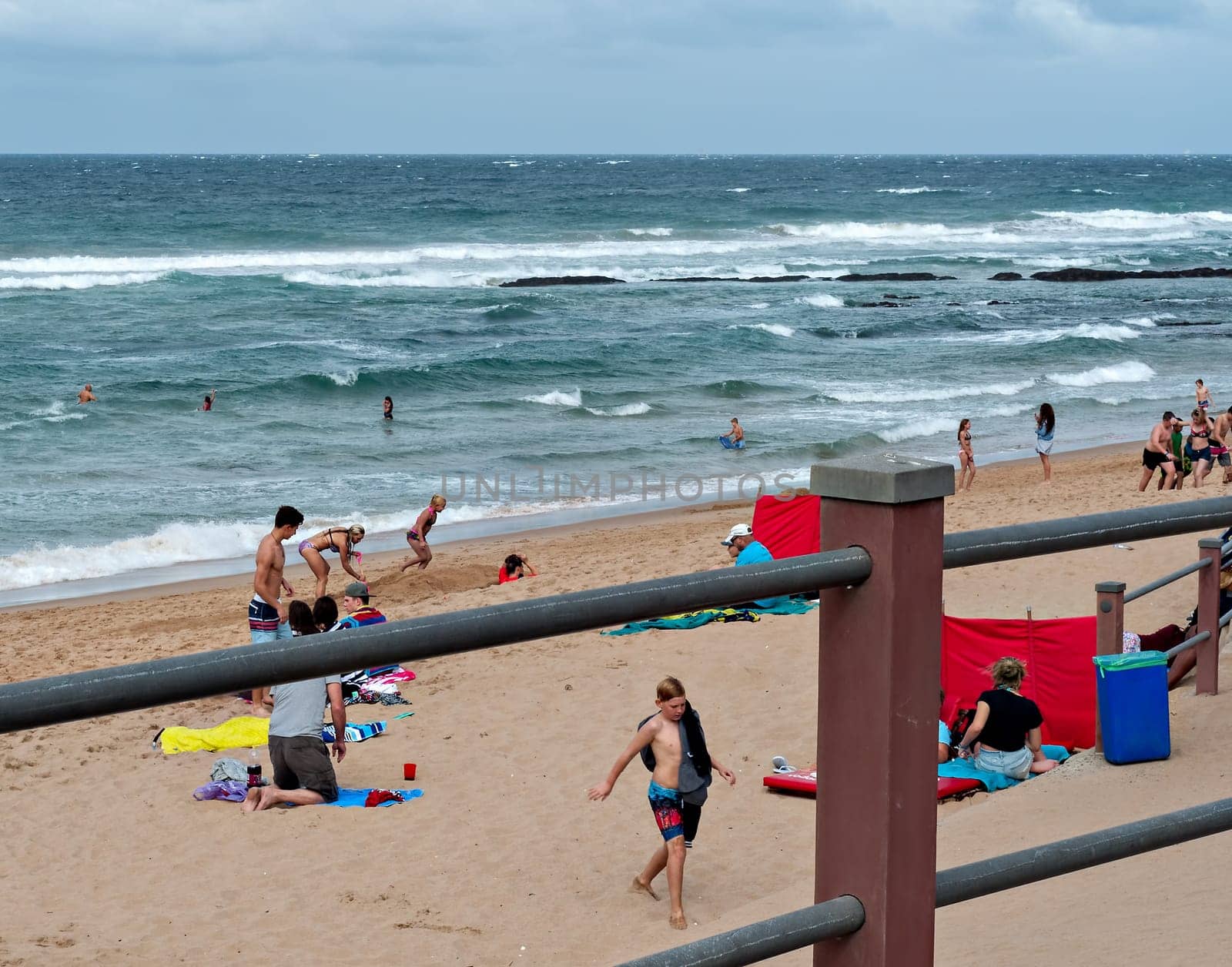 DURBAN, SOUTH AFRICA - JULY 09, 2016: Locals and tourists on the beach near the Millennium Pier and lighthouse in Umhlanga Rocks