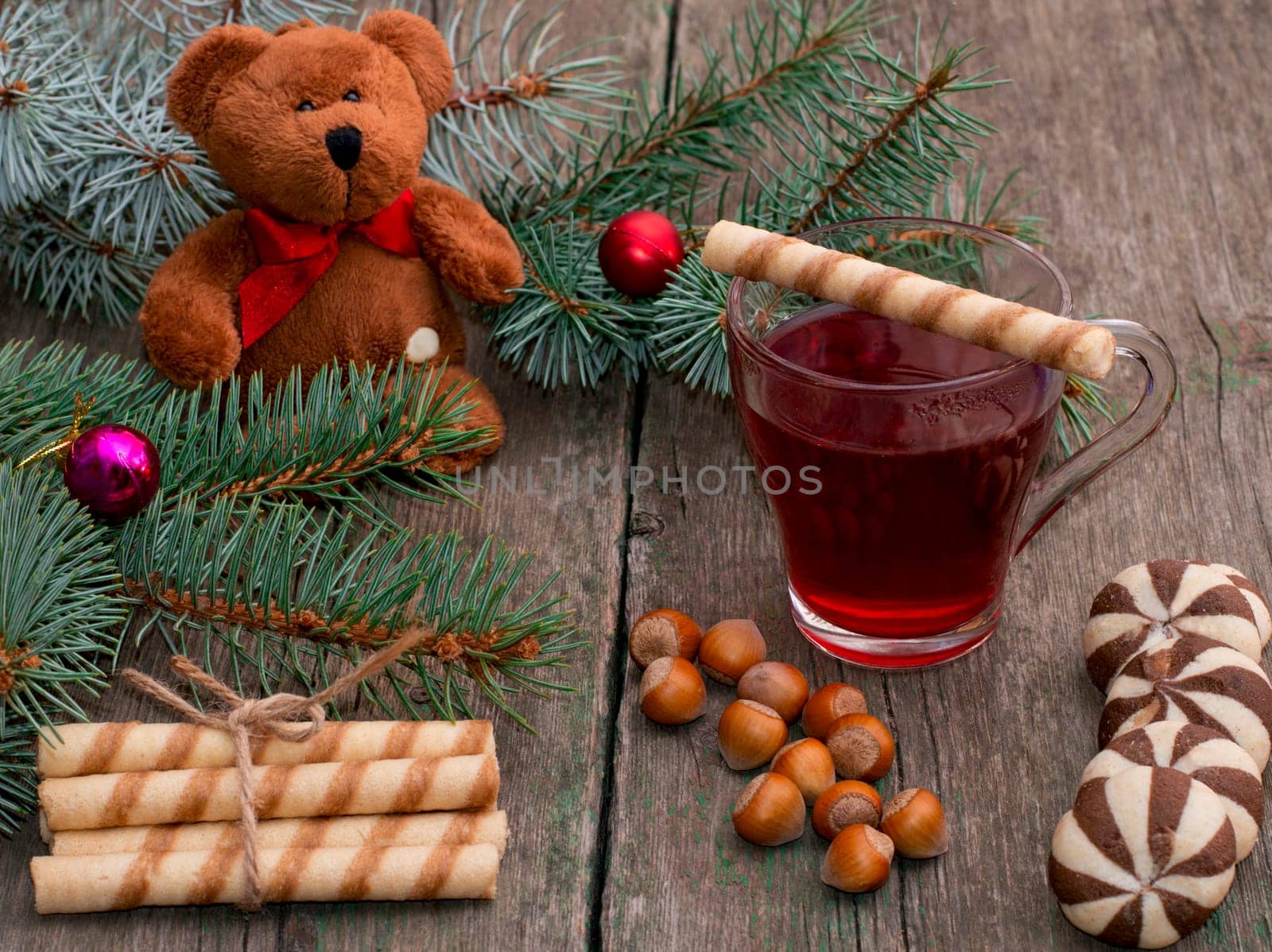 fir-tree branch, toy bear, tea, baking and nutlets, subject holidays Christmas and New Year