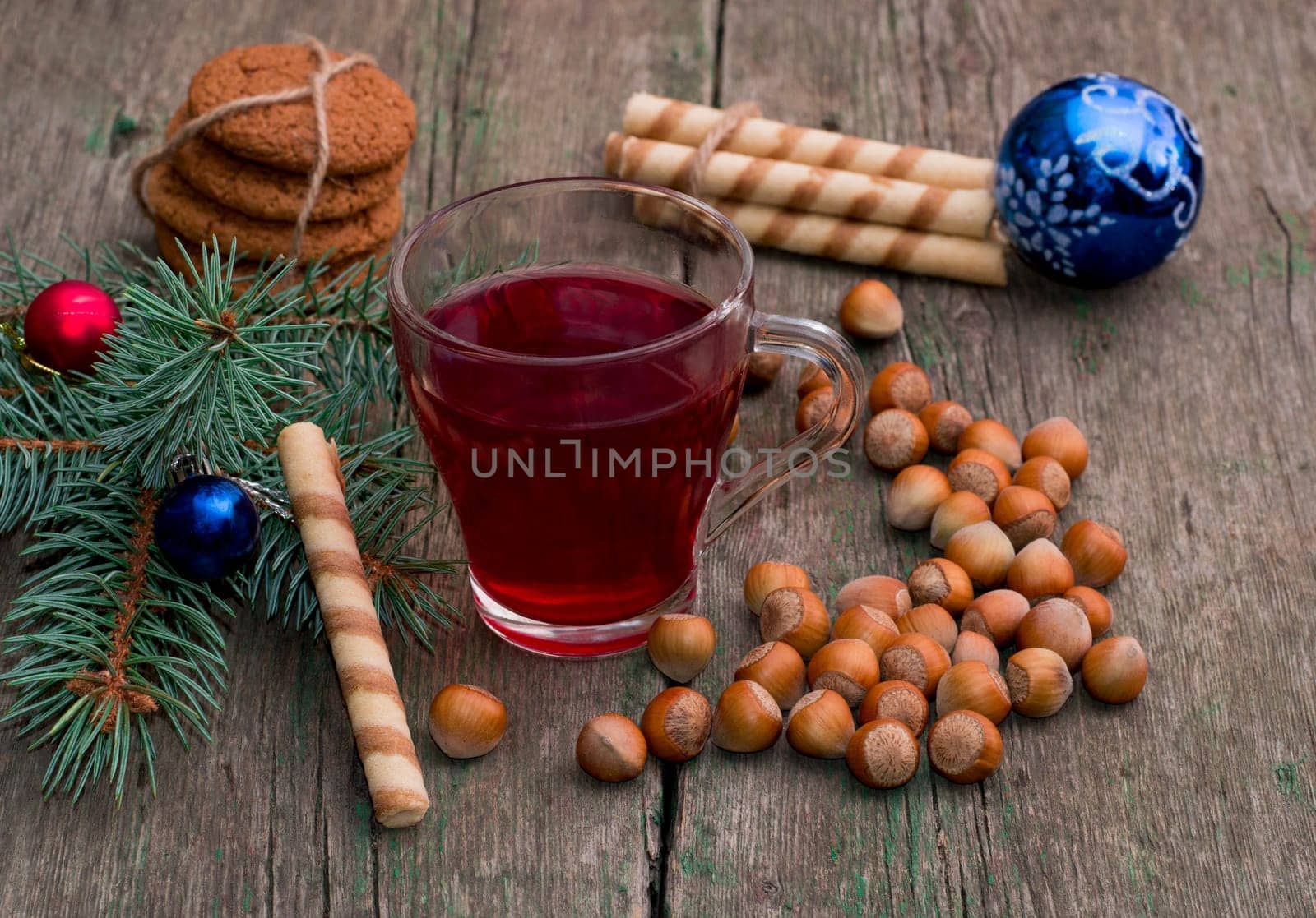 coniferous branch with Christmas tree decorations, tea, sweets and nutlets, the subject Christmas and New Year