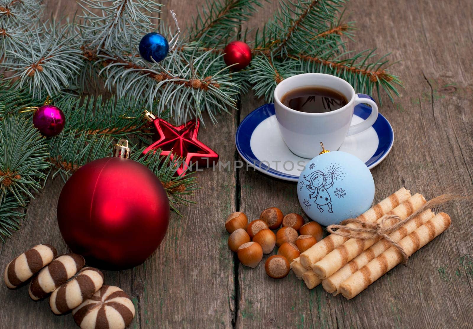 fir-tree branch with Christmas tree decorations, coffee, different baking and nutlets, a subject holidays Christmas and New Year