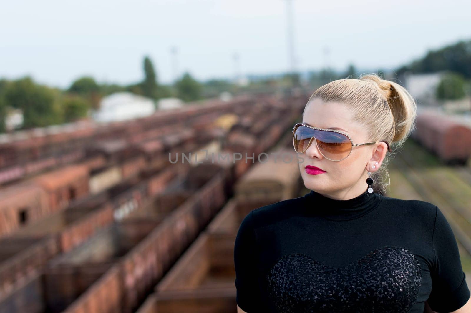 the woman's portrait on the bridge against railway cars, a subject beautiful women and railway tracks