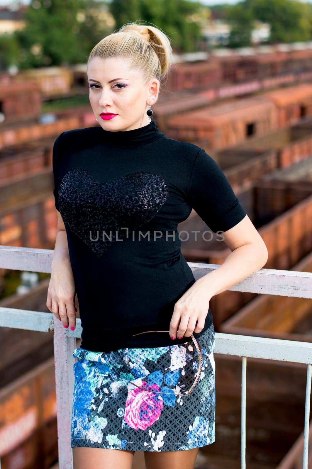 the woman's portrait at a handrail against railway cars, a subject beautiful women and railway tracks