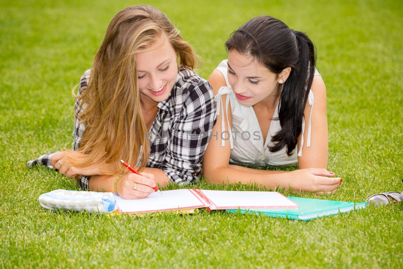 Tennage students lying on the grass and study together