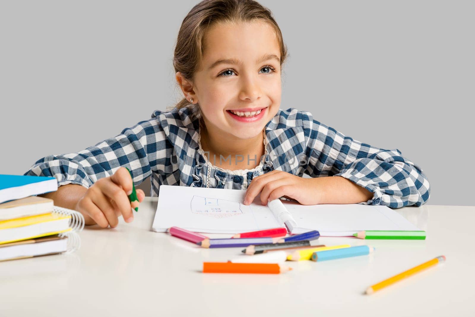 Little girl at school making drawings and painting