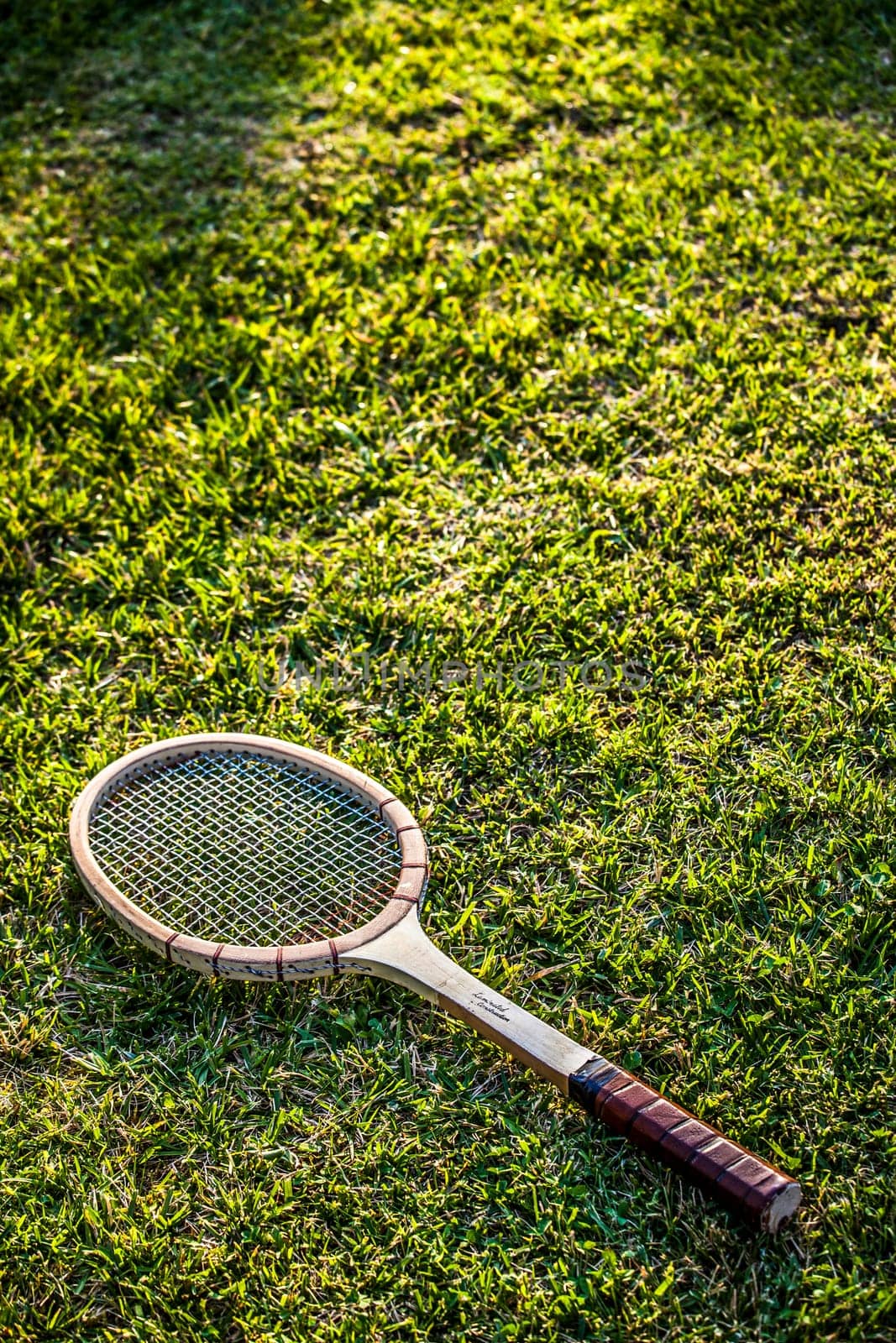 Vintage wood tennis racket on grass garden