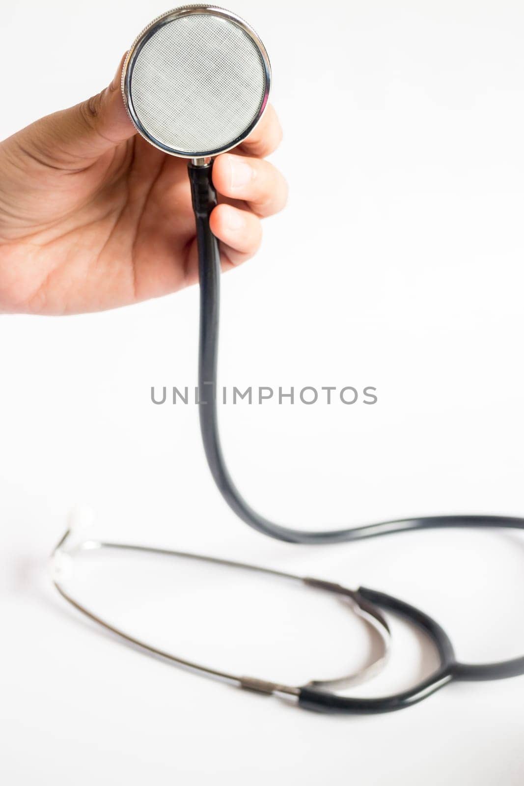 Hand on stethoscope on white background, stock photo