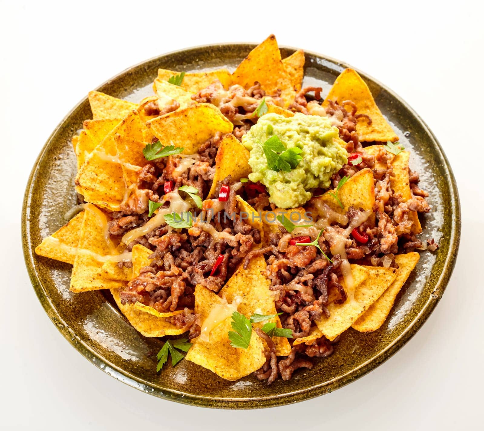 Top down view on circular ceramic plate with chips, cheese and ground beef over white background with soft set down shadow