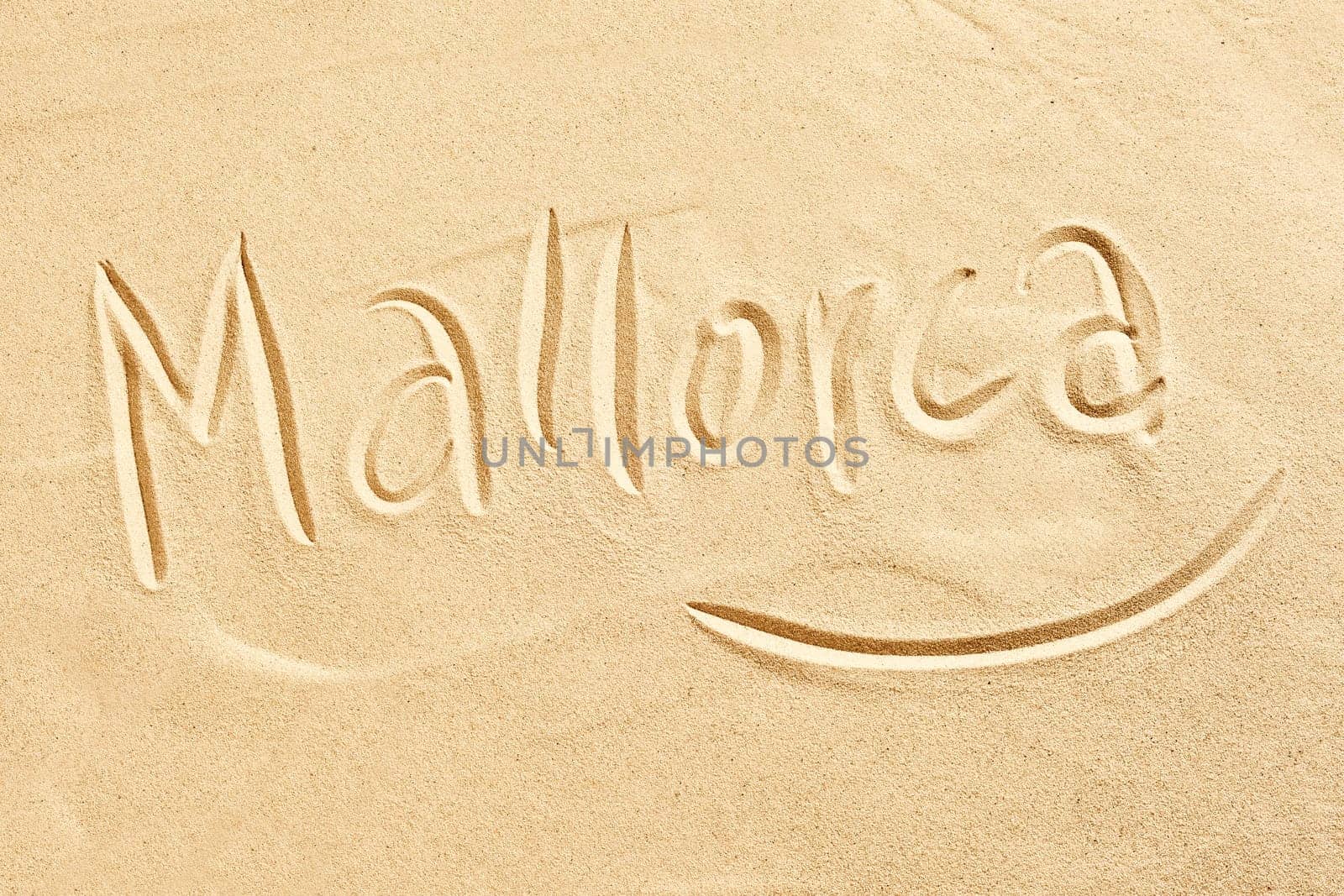 Mallorca handwritten in golden beach sand conceptual of seaside tropical summer destinations around the Mediterranean, travel and tourism