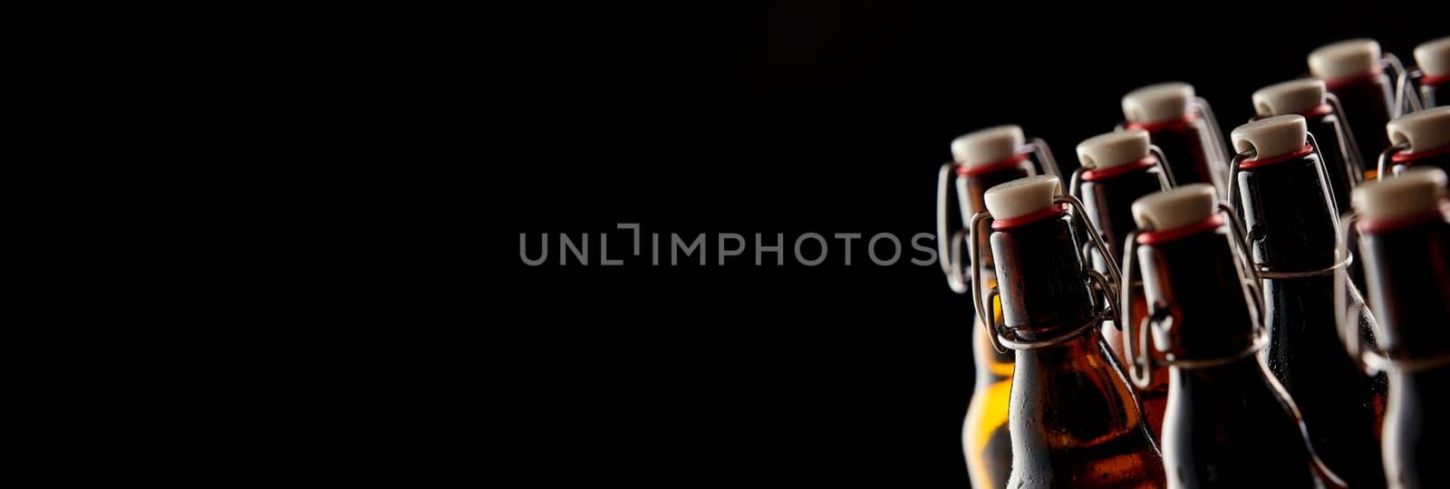 Panoramic banner with stoppered beer bottles as a right side border over black with copy space, conceptual of Oktoberfest