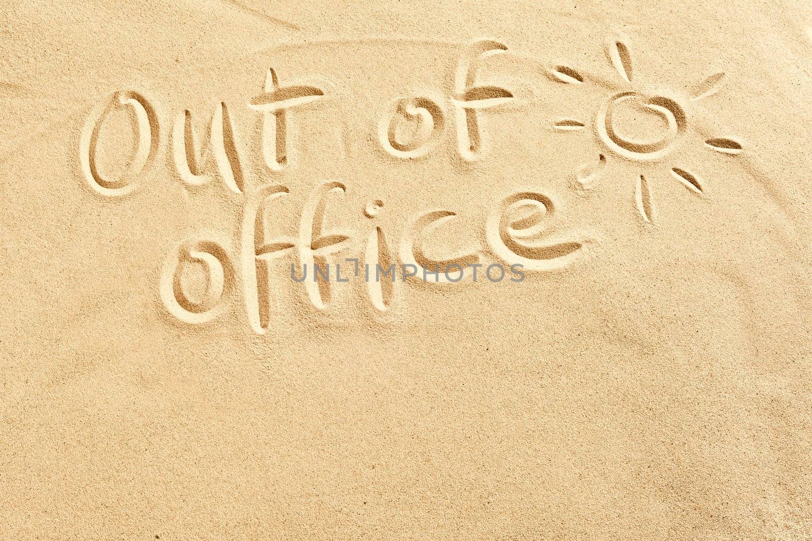 Out of office sign scribbled on beach sand with a hot shining sun and copy space conceptual of spring and summer breaks in tropical destinations