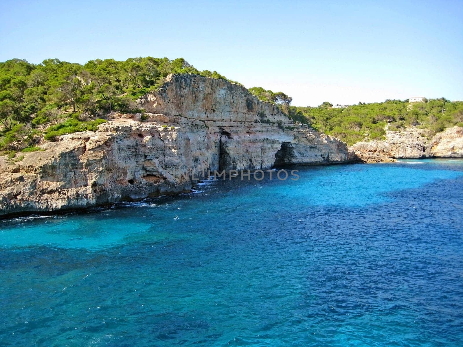 Coastline with turquoise water, mountain and caves - ocean / mediterranean sea in front