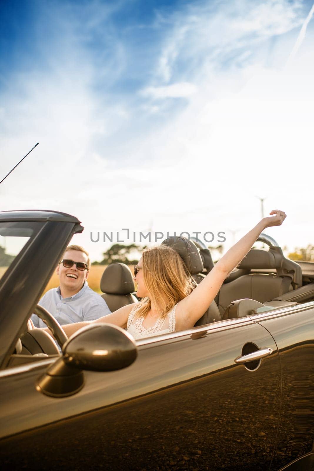 Couple in convertible looks at each other in love