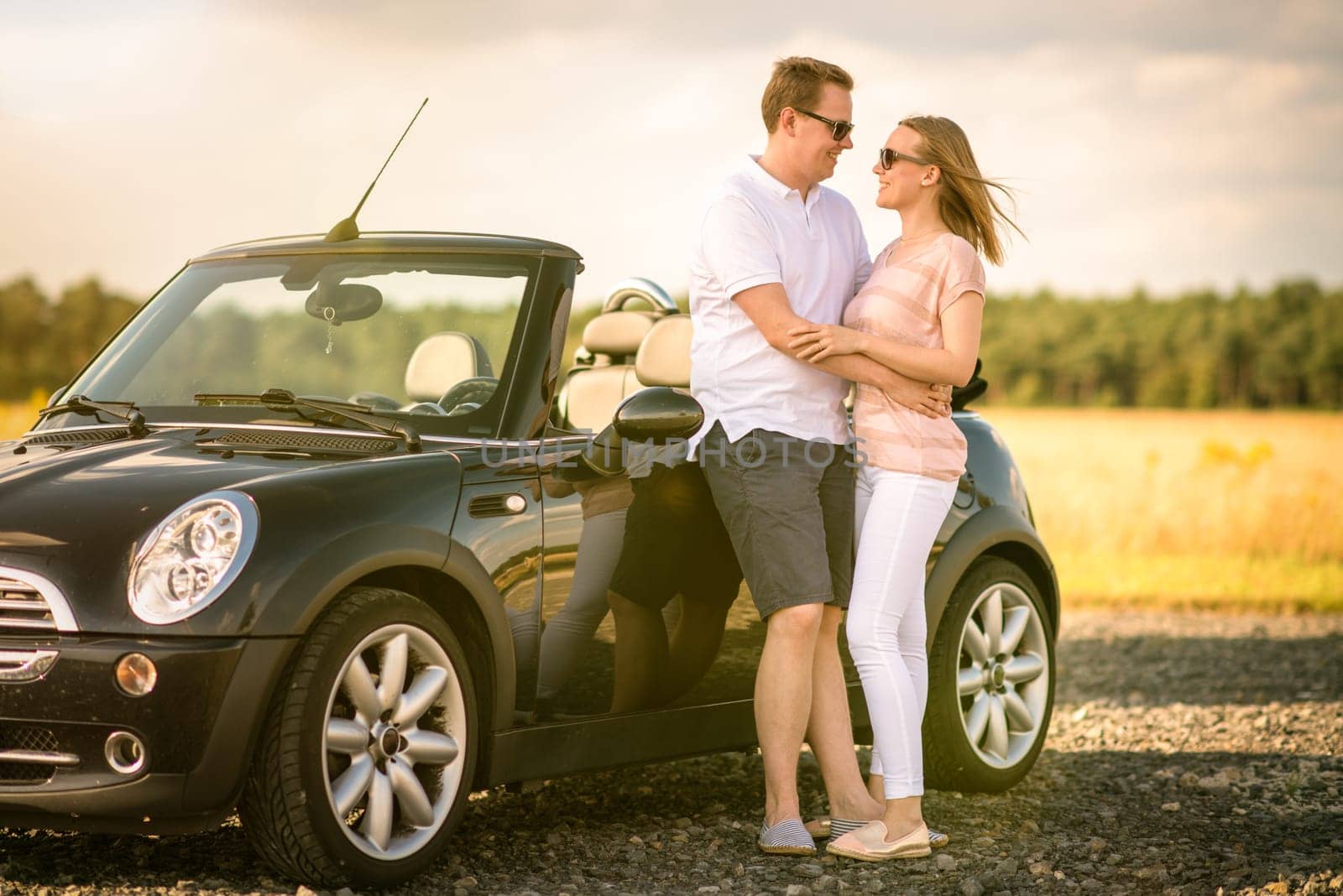 Couple is in love with the convertible and looks at each other